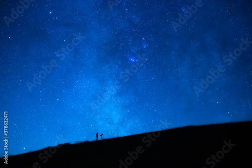 Wallpaper Mural Astronomer observing the immensity of the universe and the stars. Small silhouette of an astronomy lover with a telescope observing the blue starry sky at night. Torontodigital.ca