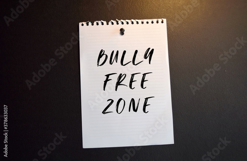 Paper note with BULLY FREE ZONE written on black slate board