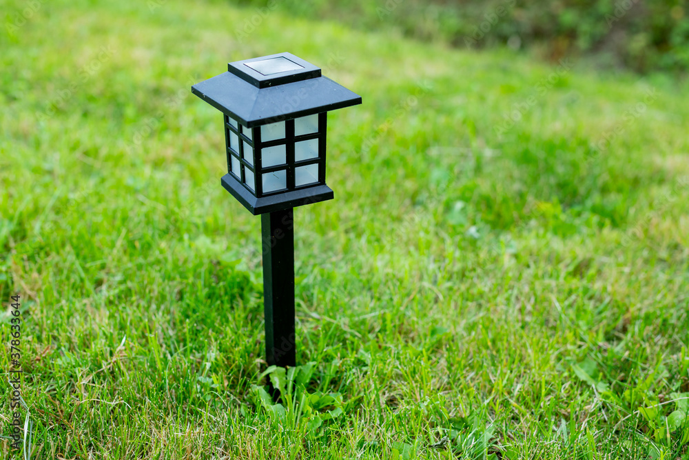 Solar cell lamp in garden and save energy of electric and save my world,close up.Charging solar lamp on the ground in the garden at sunny day, renewable energy concept.decorative spot light Solar cell lamp in garden and save energy of electric and save my world,close up.Charging solar lamp on the ground in the garden at sunny day, renewable energy concept.decorative spot light