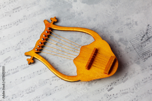 lyre - stringed plucked musical instrument on a musical background. A symbol of inspiration. photo