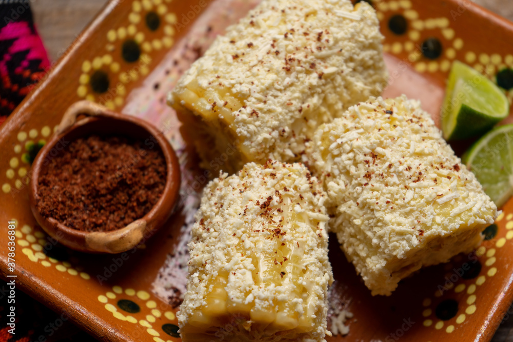 Mexican corn on the cob also called elotes with cheese and mayonnaise on wooden background Mexican corn on the cob also called elotes with cheese and mayonnaise on wooden background