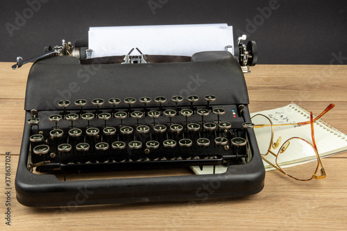 Tableau sur toile an old black portable typewriter with a steno pad and eye glasses as at a secret