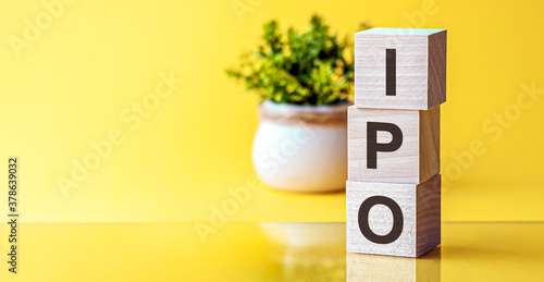 business concept IPO - acronym from wooden blocks with letters, Initial Public Offering. IPO concept, yellow background photo