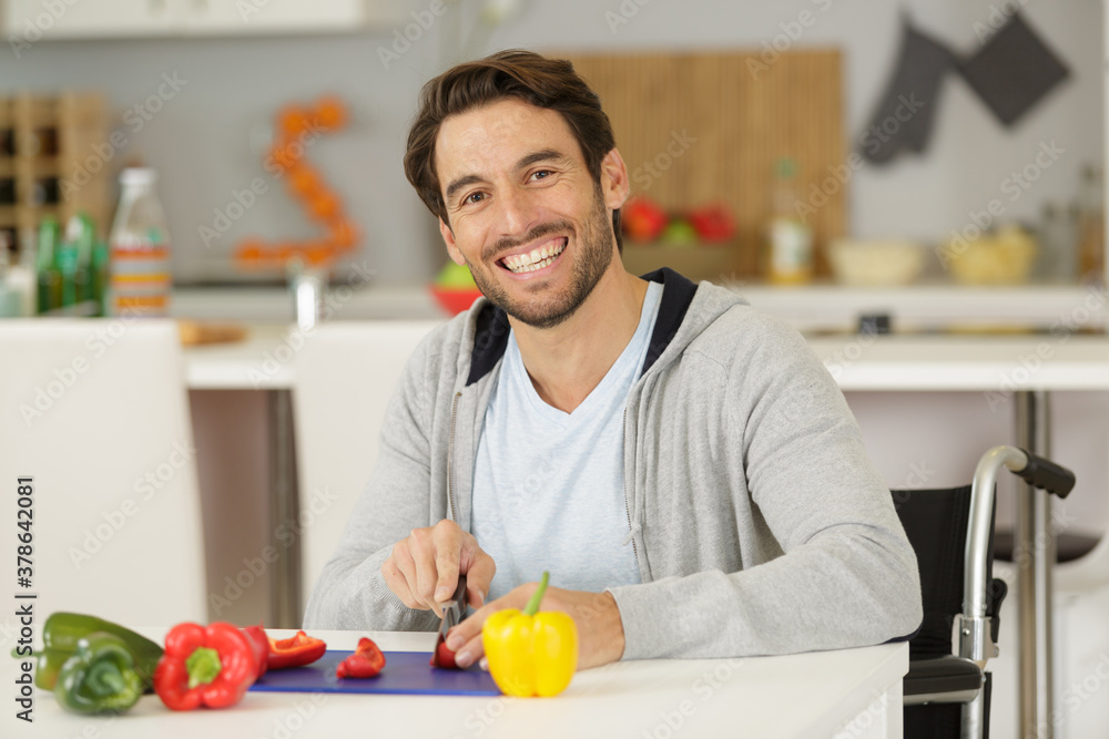 man in a kitchen cutting pepers man in a kitchen cutting pepers