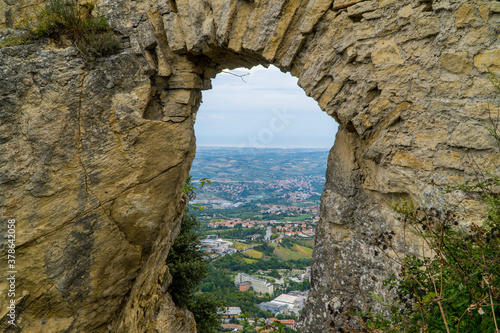 A view of towns in San Marino through a hole in the fortress wall