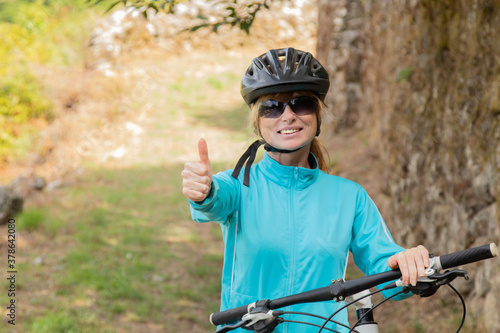 woman with bicycle and helmet outdoors