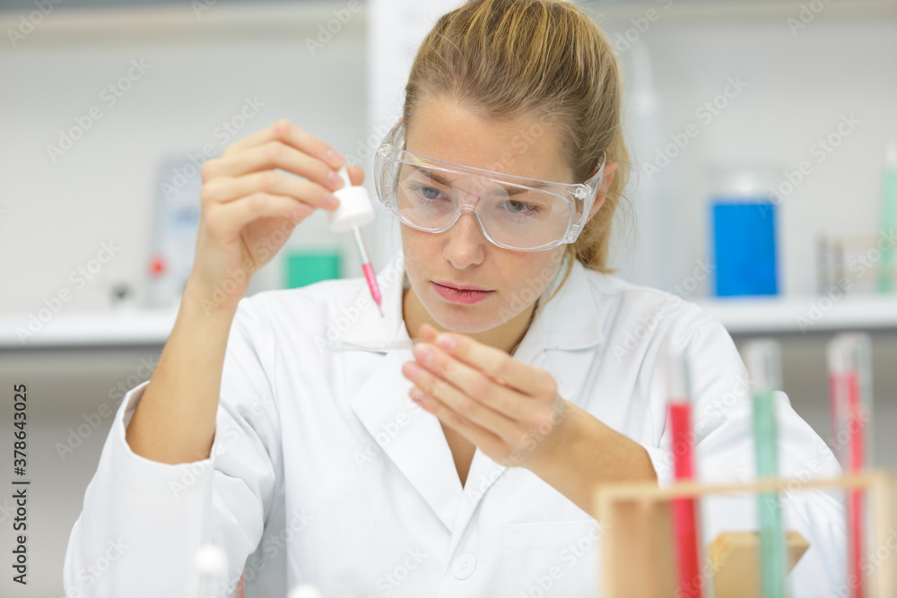 scientist pipetting solution into the glass test tube scientist pipetting solution into the glass test tube