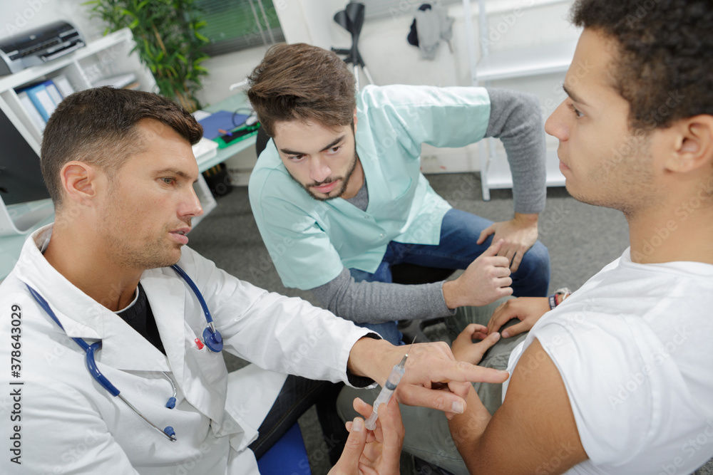 Obraz premium young nurse learning to inject a patient