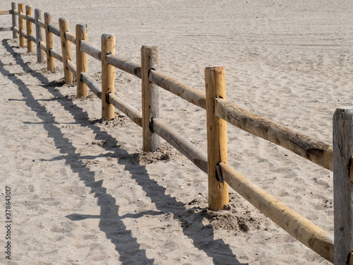 фотографія a wooden log rail and post fence like a corral on a beach sand dune