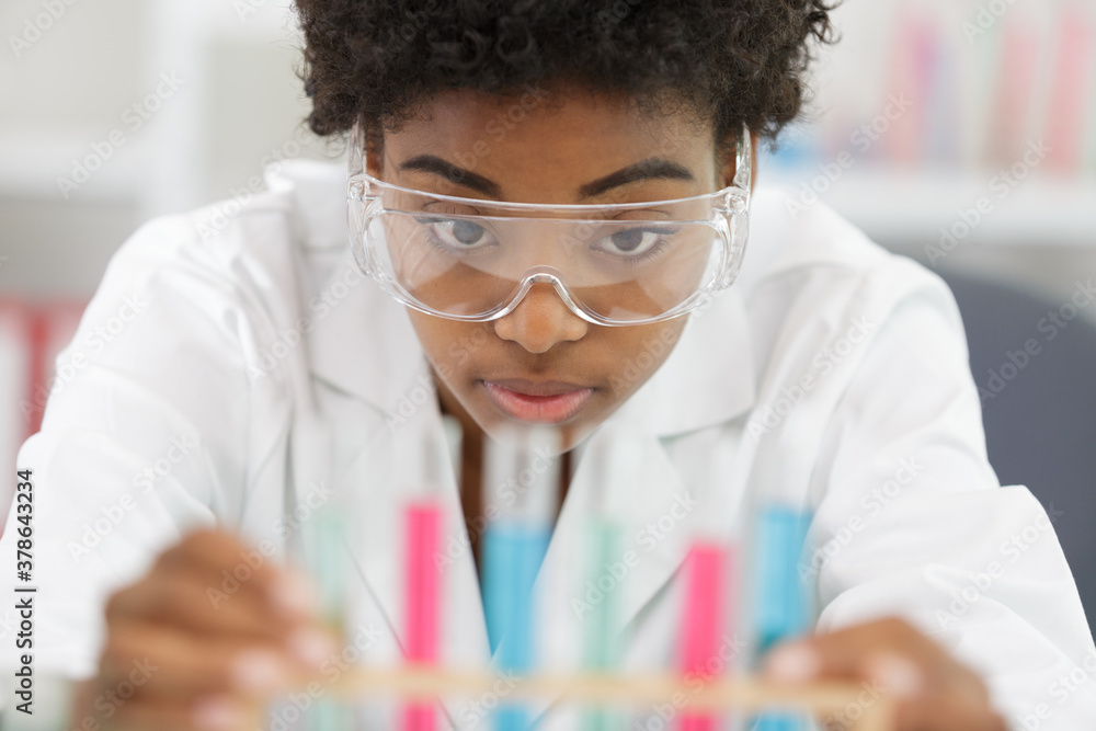 woman in the lab looking at pipettes woman in the lab looking at pipettes