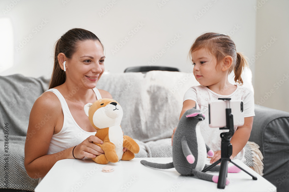 Mother with child streaming online video of unboxing toys. Influencer occupation, mommy blog Mother with child streaming online video of unboxing toys. Influencer occupation, mommy blog
