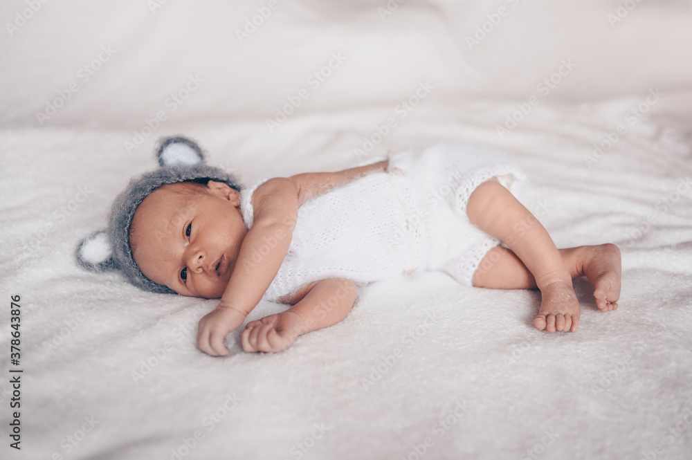 Cute emotional newborn little baby boy sleeping in crib in a knitted suit with ears. Baby goods packaging template. Healthy child, concept of hospital and happy motherhood. Infant baby. Nursery Cute emotional newborn little baby boy sleeping in crib in a knitted suit with ears. Baby goods packaging template. Healthy child, concept of hospital and happy motherhood. Infant baby. Nursery