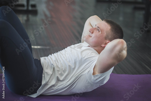 Athlete trains abdominal muscles on the floor in the gym