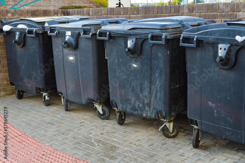 garbage containers are in the city. black capacious containers for storing various garbage in the city center. separate collection of secondary waste and repair products