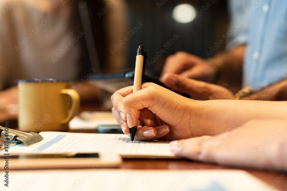 close up detail of latin hands with pen writing notes on clipboard in co-working open space. Communication, workspace, meeting concept.. close up detail of latin hands with pen writing notes on clipboard in co-working open space. Communication, workspace, meeting concept..