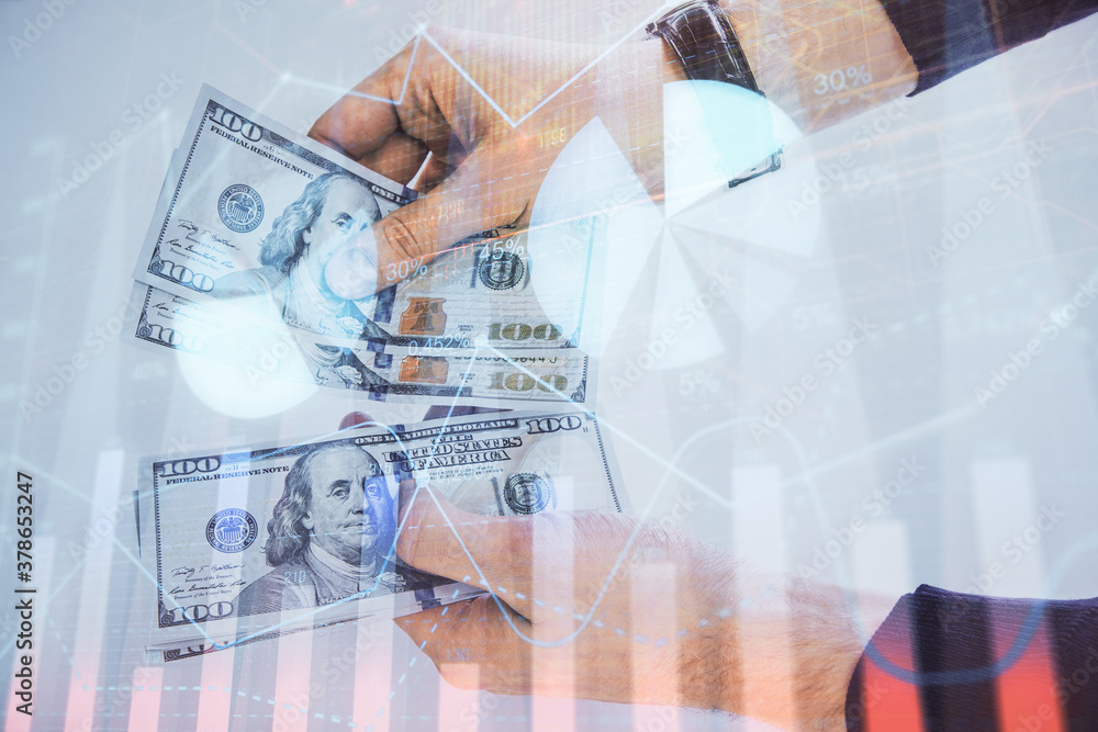 Multi exposure of financial graph drawing hologram and USA dollars bills and man hands. Analysis concept. Multi exposure of financial graph drawing hologram and USA dollars bills and man hands. Analysis concept.