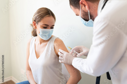 Doctor applying a vaccine on a woman's arm photo