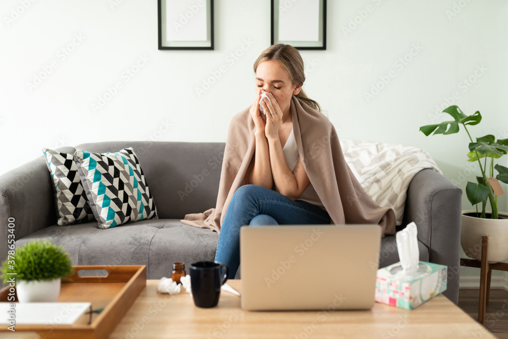 Adult woman blowing her nose at home