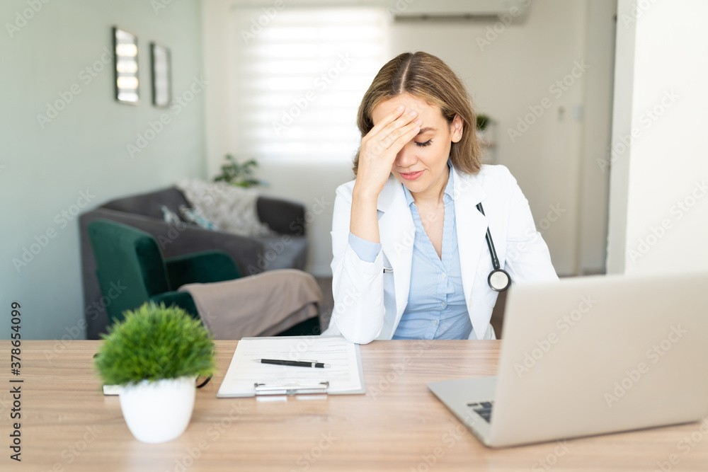 Doctor feeling stressed and doing paperwork Doctor feeling stressed and doing paperwork