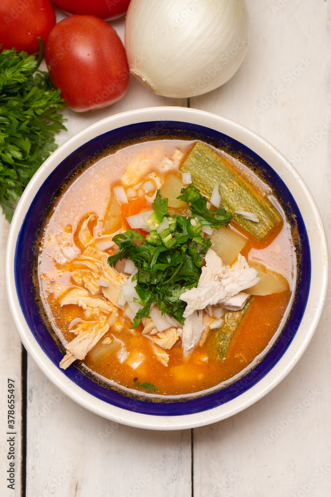Mexican chicken soup with vegetables and rice on white background Mexican chicken soup with vegetables and rice on white background