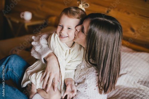 Cuadro en lienzo Young mother and her daughter playing and having fun in a cozy log cabin