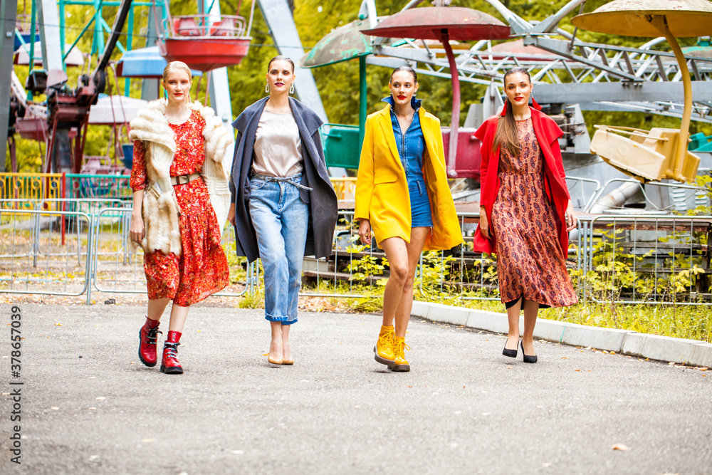 Fototapeta premium Four fashion models walking in autumn park