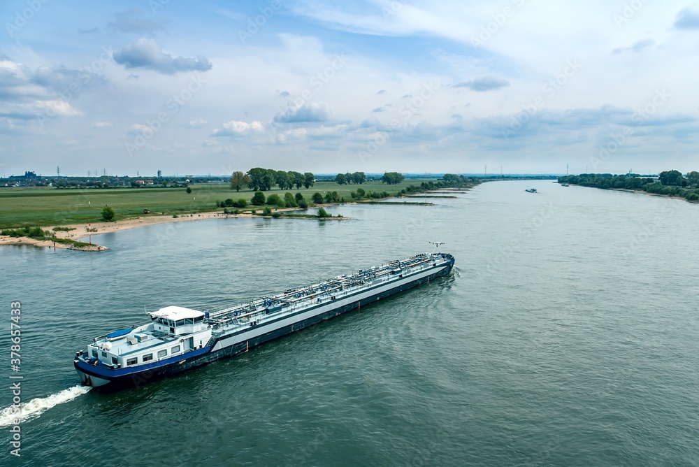 Trawler navigating a rive . Cargo ship . International logistics . Delivery of cargo by river