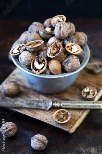Walnuts in a bowl on a dark background.