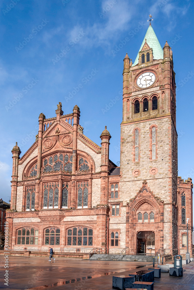 Façade of Guildhall in Derry / Londonderry, Northern Ireland, built in the 19th century with red bricks and the clock tower, meeting place of the local city council.