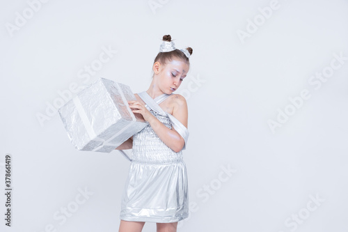 girl girl with tails horns in a silver dress holds a gift box.