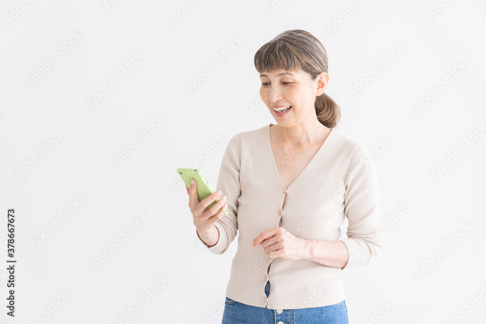 スマートフォンを見るシニア女性 スマートフォンを見るシニア女性