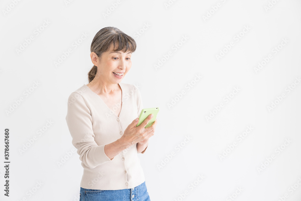 スマートフォンを見るシニア女性 スマートフォンを見るシニア女性