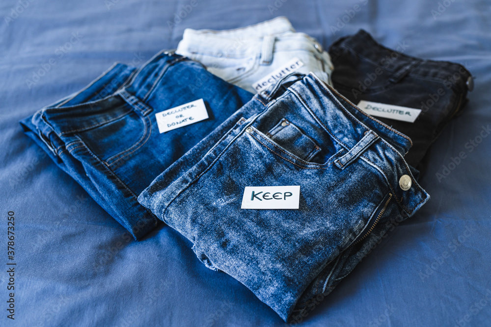 Naklejka premium Keep vs Declutter label on different jeans in various denim colors, tidying up concept