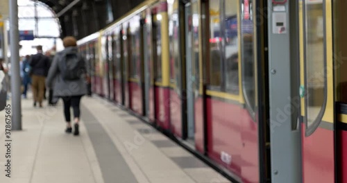 Wallpaper Mural Defocused and blurry background of passengers on platform, closing automatic door and departing train at train station  in Berlin, Germany. Torontodigital.ca