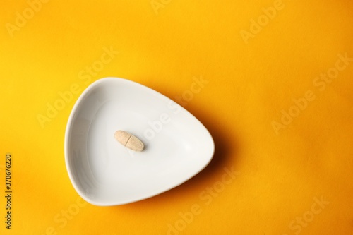 Daily vitamins on the white background. Light brown pills isolated on white. Multivitamins.