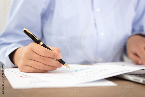 Close-up shot of a pen while viewing documents photo