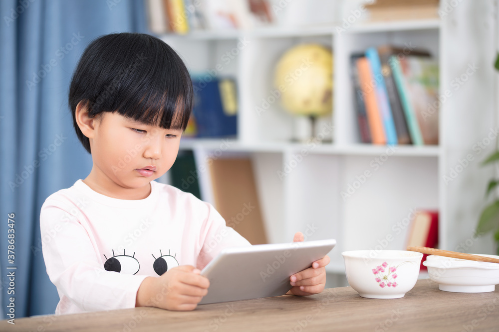 Cute girl is using tablet to learn