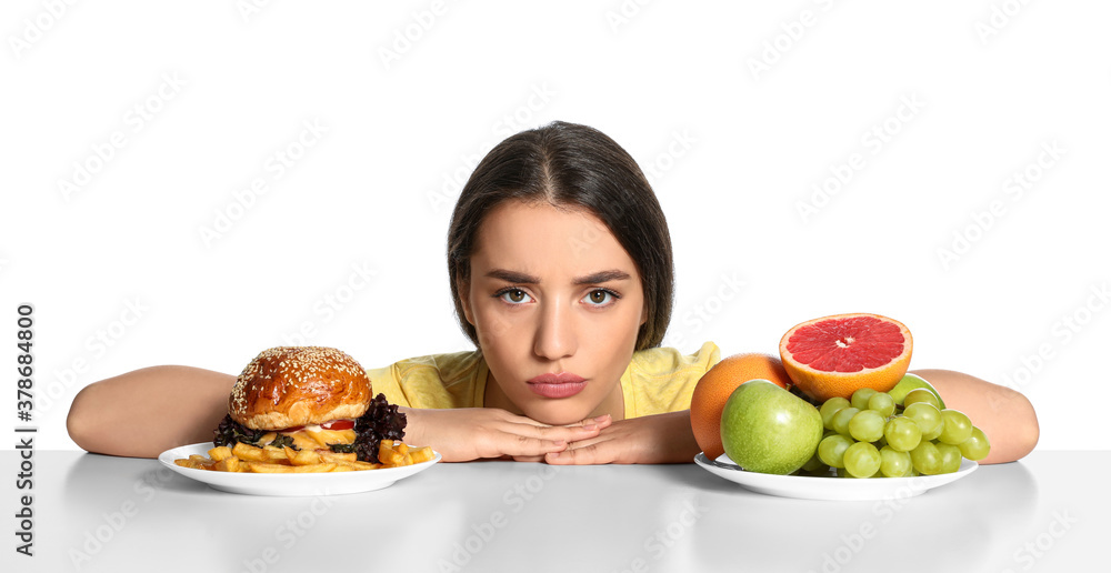 Woman choosing between fruits and burger with French fries on white background Woman choosing between fruits and burger with French fries on white background