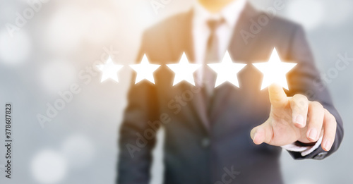 Hand of businessman touching five star symbol to increase rating of company concept