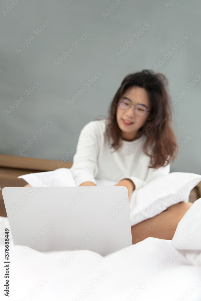 Chinese girl working on bed in bedroom early in the morning