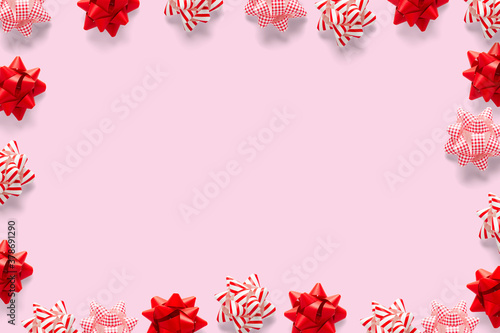 Christmas composition. Christmas gift, knitted blanket, pine cones, fir branches on pink background. Flat lay, top view, copy space