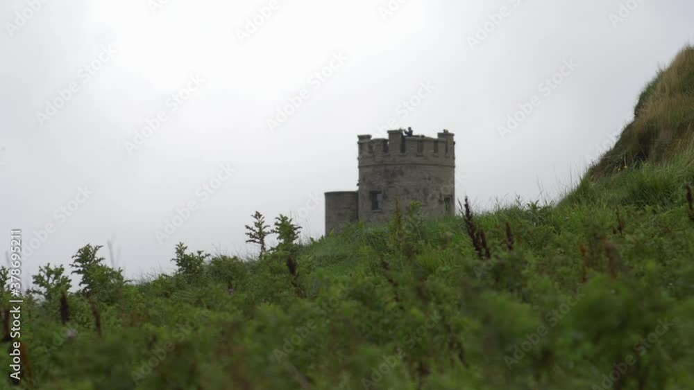 Castle tower far away across meadow on a cloudy day - rack focus shot Castle tower far away across meadow on a cloudy day - rack focus shot