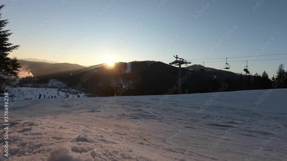 Landscape of many skiers and ski lift at ski resort in the Bukovel, Ukraine. Time Lapse the sun goes down and starts to get dark. Beautiful nature with snowy mountains and forests Landscape of many skiers and ski lift at ski resort in the Bukovel, Ukraine. Time Lapse the sun goes down and starts to get dark. Beautiful nature with snowy mountains and forests