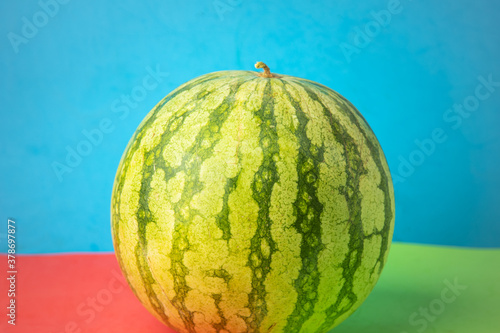 green watermelon on colorful background