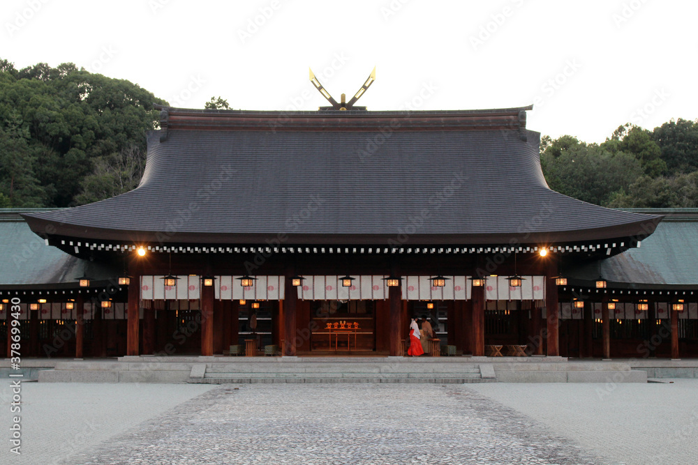 Miko or priestess of Kashihara Jingu Temple lighted by lanterns in Nara
