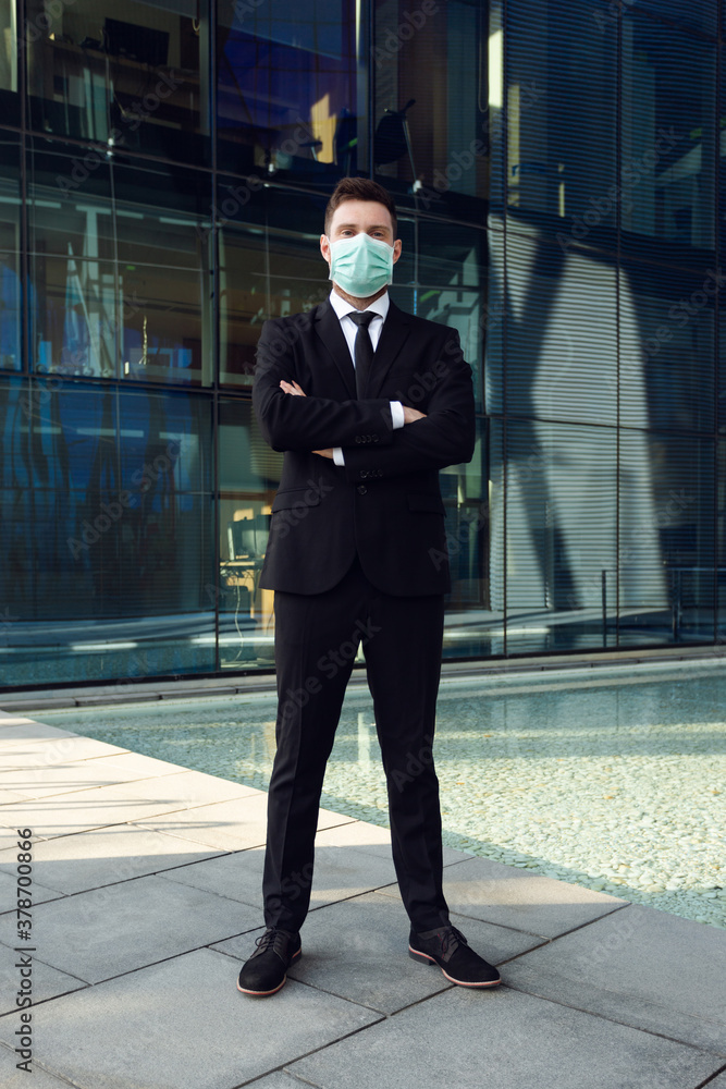Businessman Wearing Medical Mask in Business Center Hands Crossed. Business man in Black Suit
