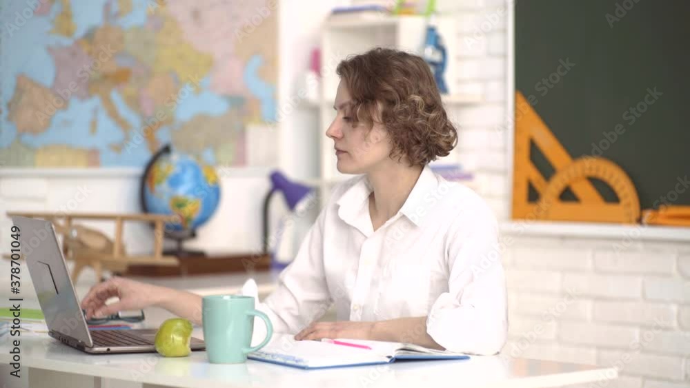 Female student taking notes from a book in college. Young Caucasian female teacher. Students and tutoring education concept. Female student taking notes from a book in college. Young Caucasian female teacher. Students and tutoring education concept.