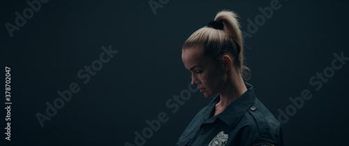 FIXED Portrait of Caucasian female police officer posing against dark background
