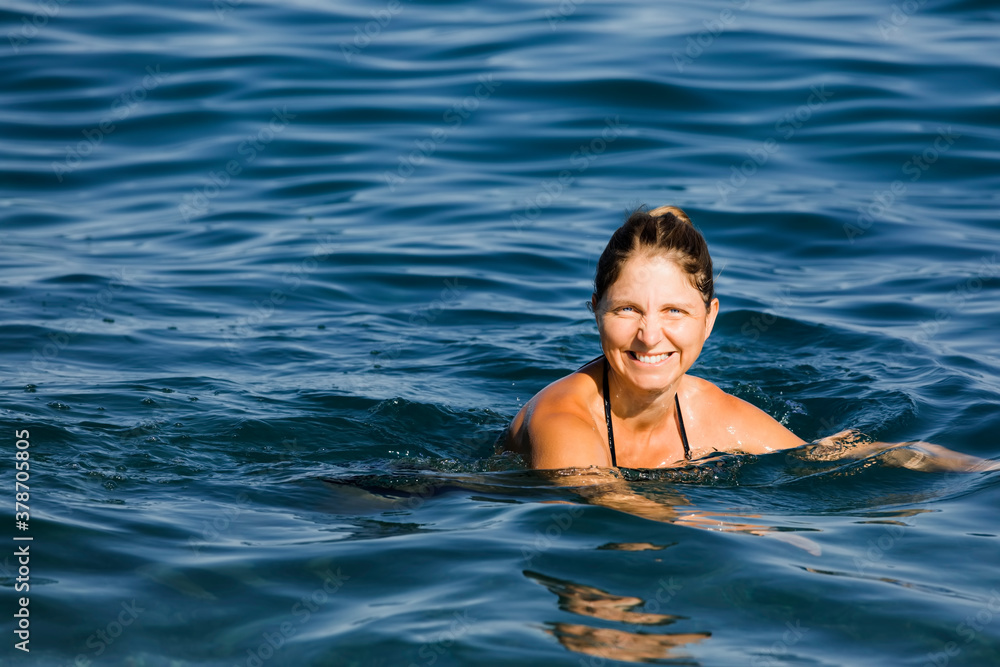 Happy woman swimming in sea