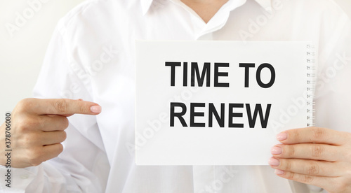 Fotografi Businesswoman holding a card with text TIME TO RENEW, business concept